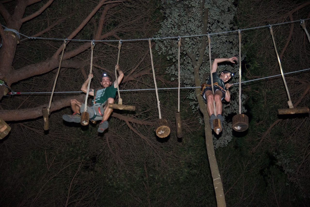 Participantes haciendo un circuito nocturno entre árboles